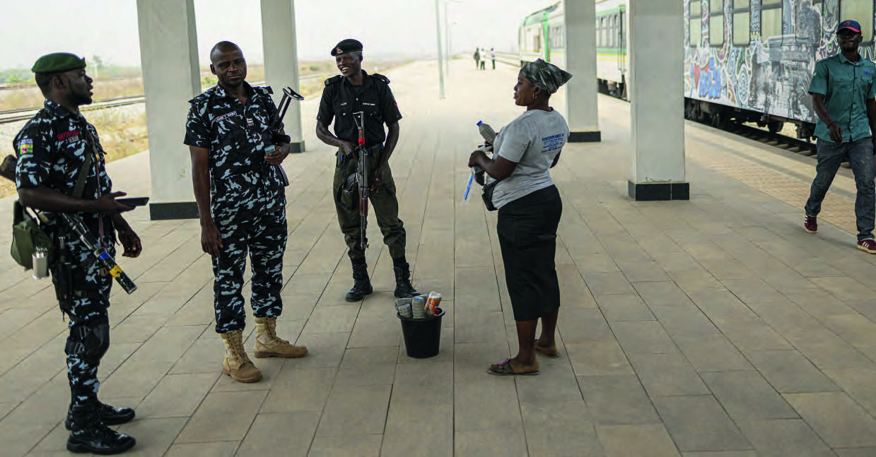 Soldiers stand watch as passengers board the Abuja-Kaduna train. The line was attacked in March 2022. MICHELE SPATARI/AFP