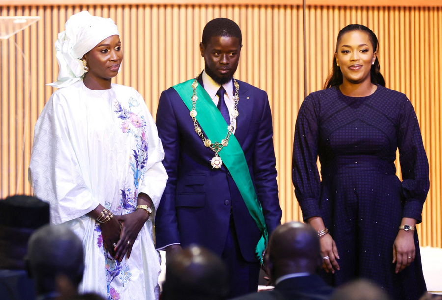 The Senegalese president surrounded by his two wives, Marie Khone Faye (left) and Absa Faye (right), after his swearing in on April 2, 2024, in Diamniadio. CEM OZDEL/ANADOLU/ANADOLU VIA AFP